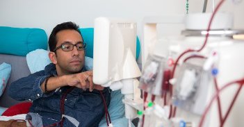 Jongen met bril ligt in bed en zit aan een medisch apparaat aangesloten.