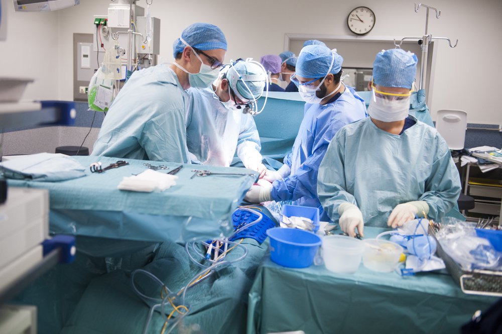 Je ziet chirurgen bezig met een niertransplantatie