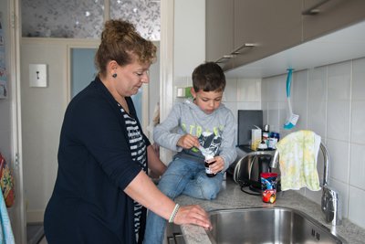 Je ziet een moeder met kind die op het aanrecht zit