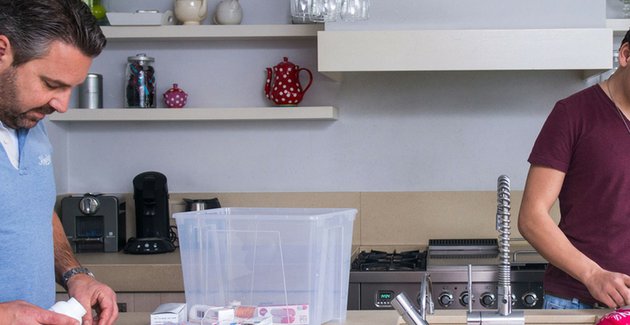 Vader staat met kinderen in de keuken
