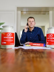 Je ziet Rob Leliveld met 2 collectebussen